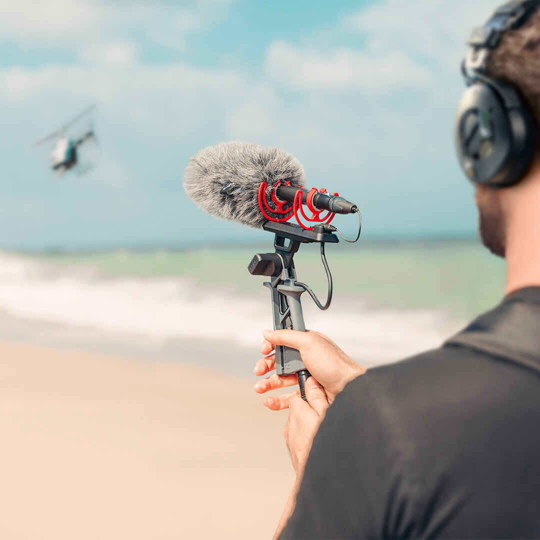 Sound recordist wearing NTH-100 pointing NTG5 at helicopter